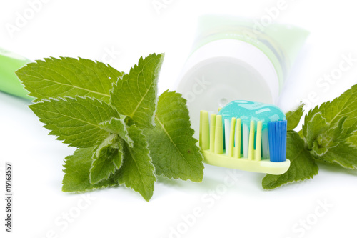 Toothbrush  toothpaste and fresh leaves of mint