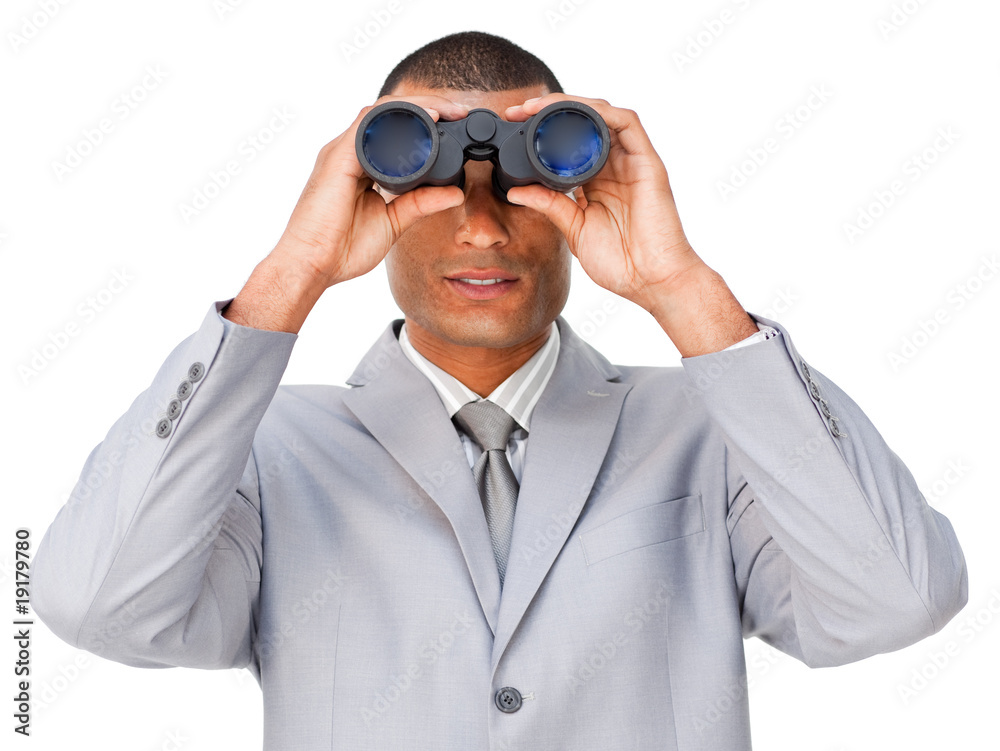 Serious young businessman looking through binoculars Serious young businessman looking through binoculars