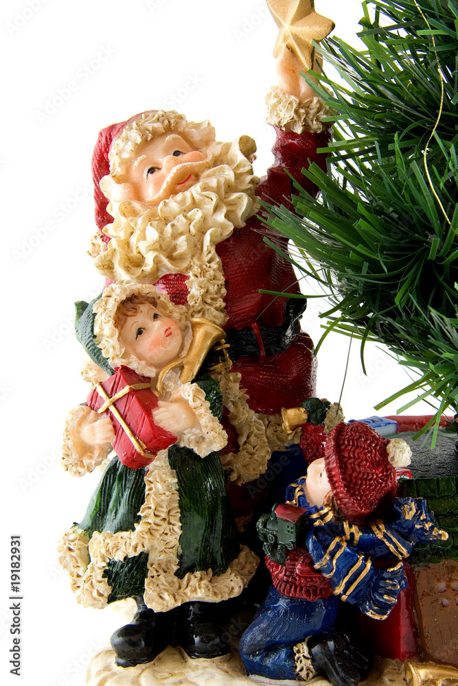 Statue of Santa Claus with children bij bare christmas tree