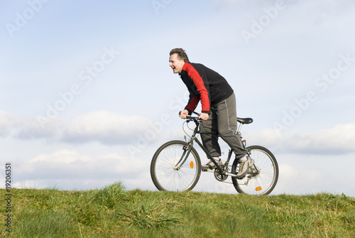 A happy laughing man cycling uphill