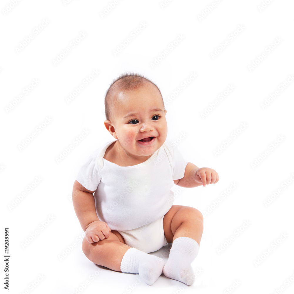 Happy smiling infant baby dressed in white sitting isolated Happy smiling infant baby dressed in white sitting isolated