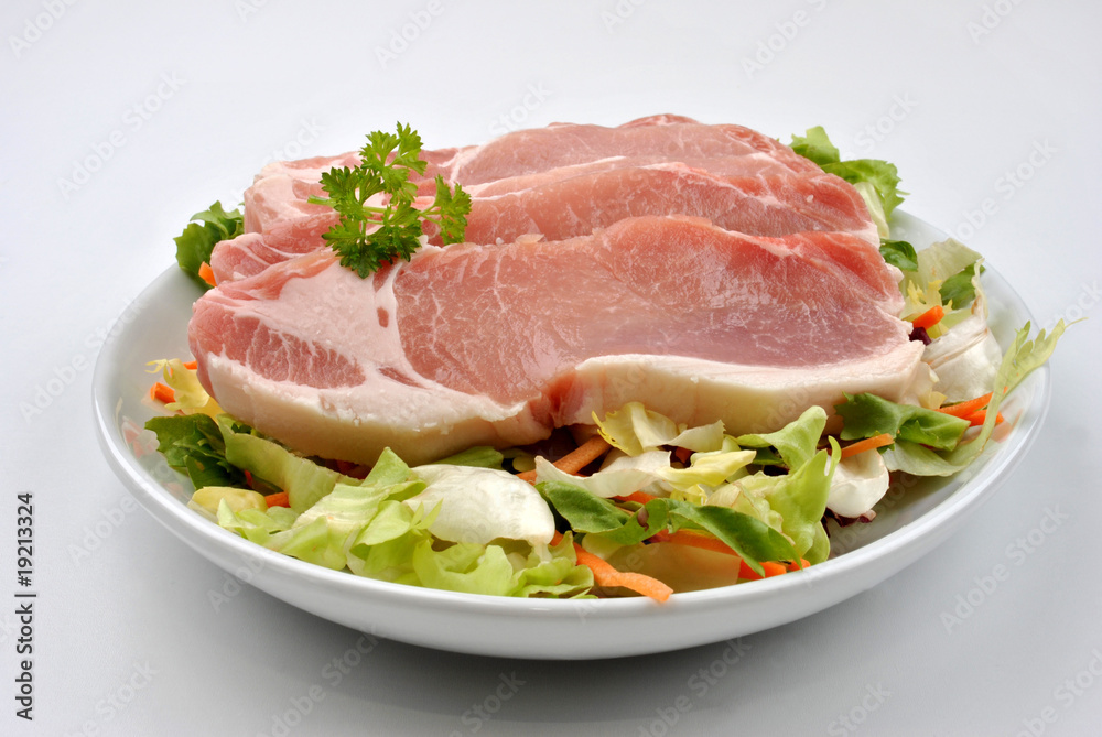 raw organic pork chop and salad