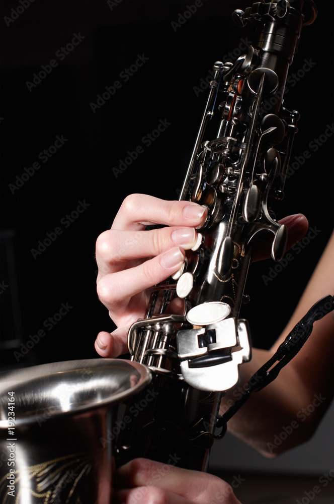 Fototapeta premium hand on buttons of saxophone