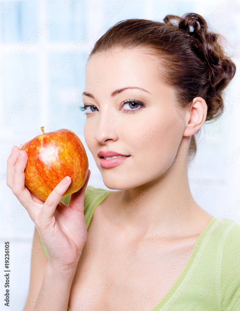 Portrait of a beautiful young female with red apple