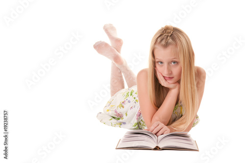 Little girl laying on a floor reading a book