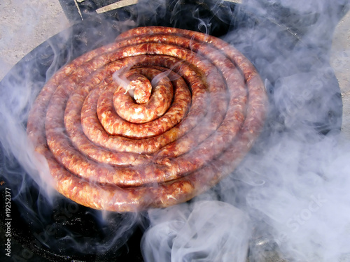 Sausage on barbecue with wooden coals