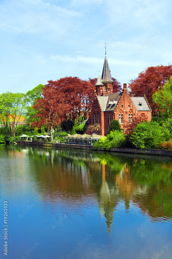 Old brick castle on water under blue sky