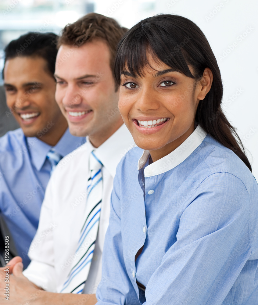Multi-ethnic young business team sitting in a row Multi-ethnic young business team sitting in a row