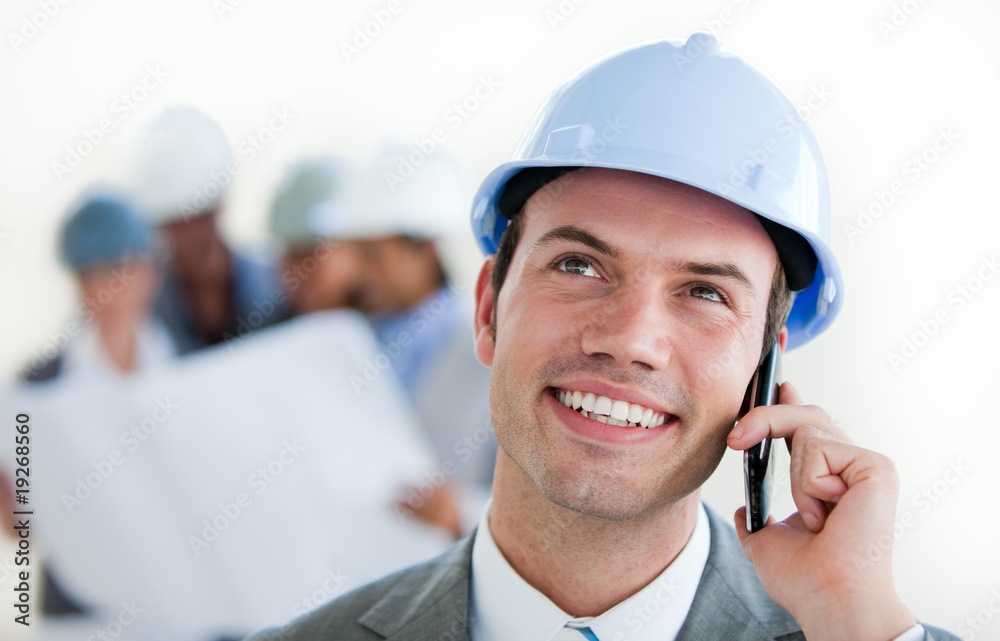 Focus on a male arhitect with a hardhat on phone Focus on a male arhitect with a hardhat on phone