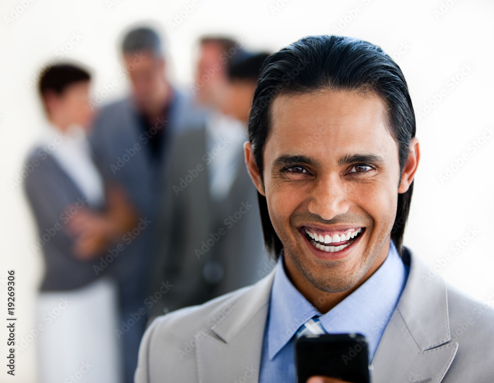 Cheerful ethnic businessman sending a text Cheerful ethnic businessman sending a text