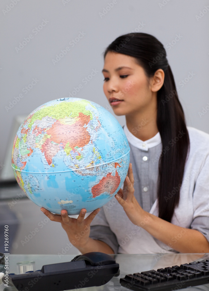 Concentrated businesswoman looking at a globe Concentrated businesswoman looking at a globe