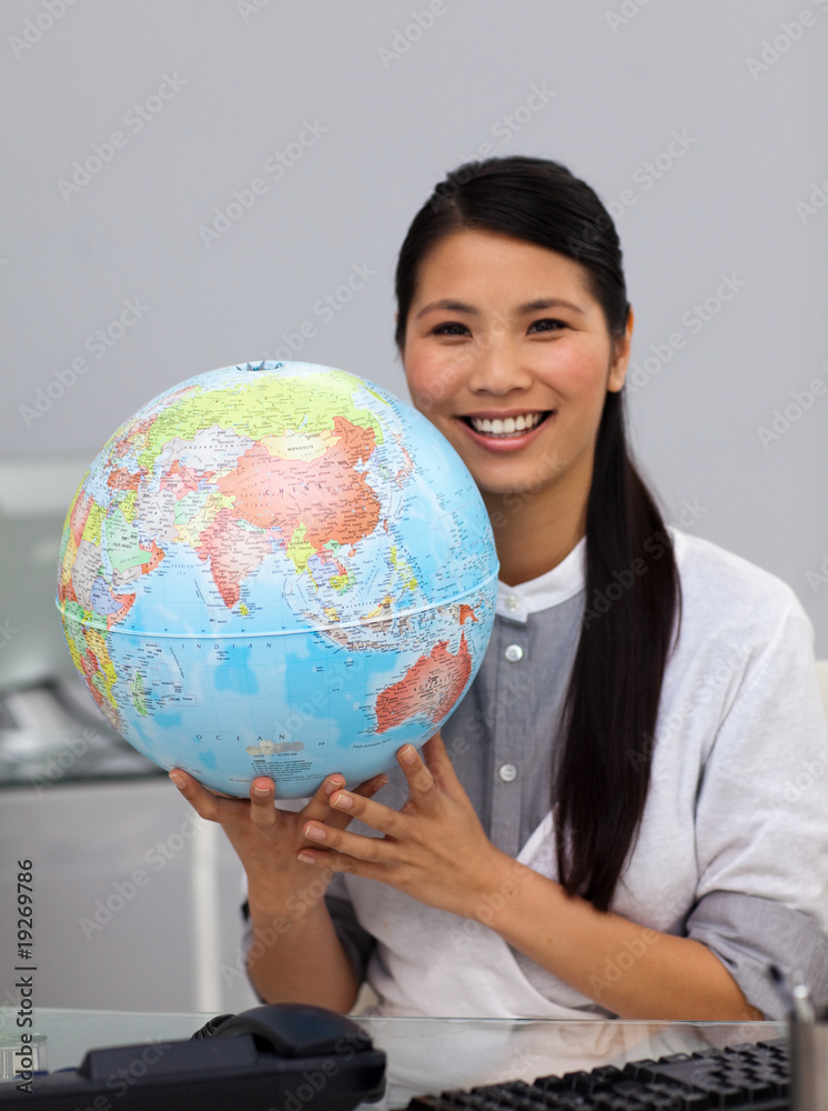 Assertive asian businesswoman holding a globe Assertive asian businesswoman holding a globe