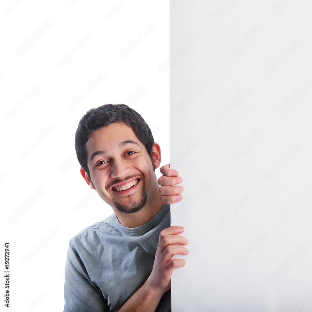 Smiling young man behind large poster board sign Smiling young man behind large poster board sign