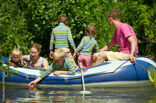 Children and adults float on an inflatable boat