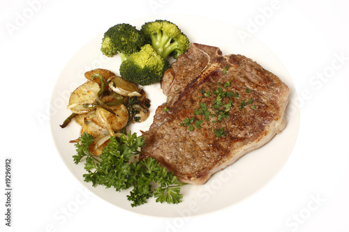 T-Bone steak dinner with sides of potatoes and broccoli