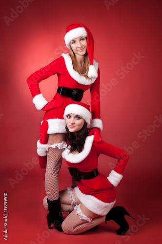 Two sexual women in dressed as Santa.