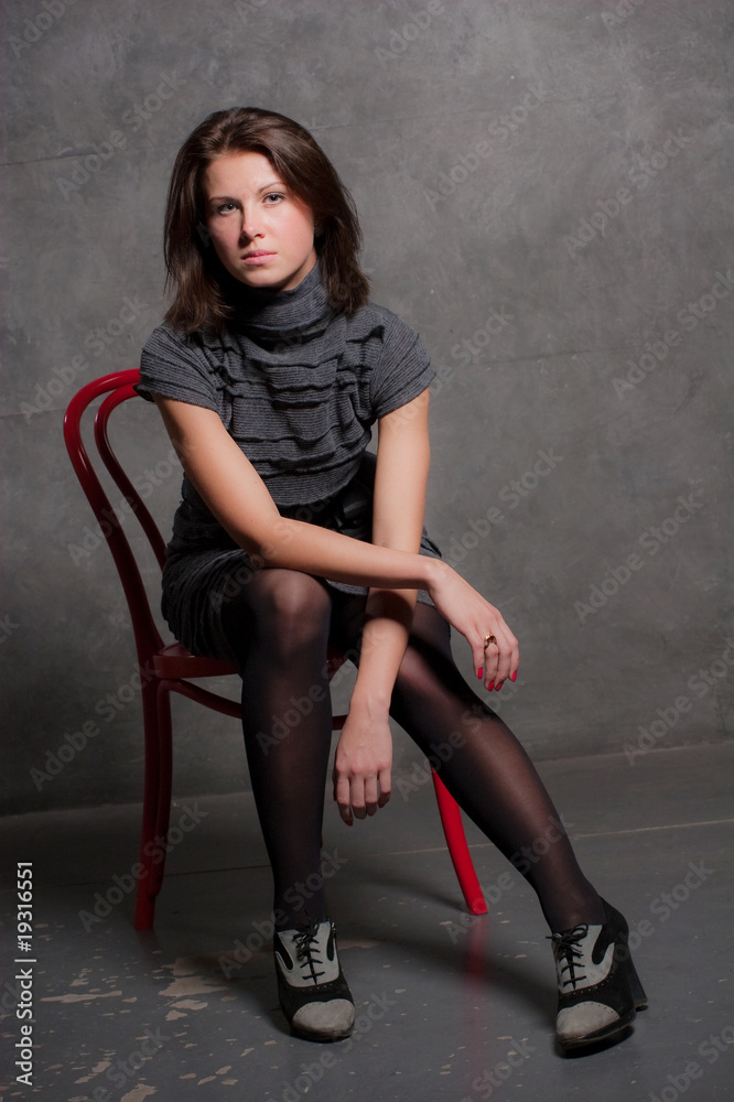 Fototapeta premium Portrait of the young girl sitting on a chair