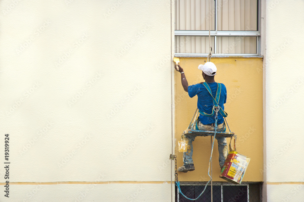 Hanging Painter painting wall with brush