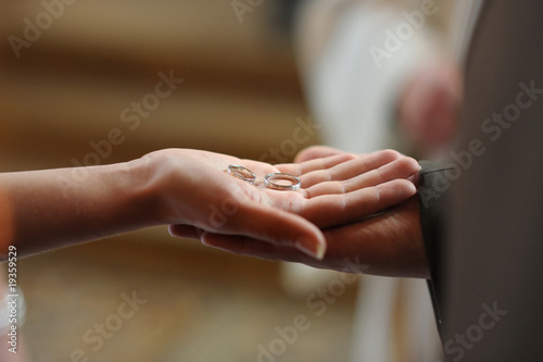 Groom holding bride's hand with two wedding rings
