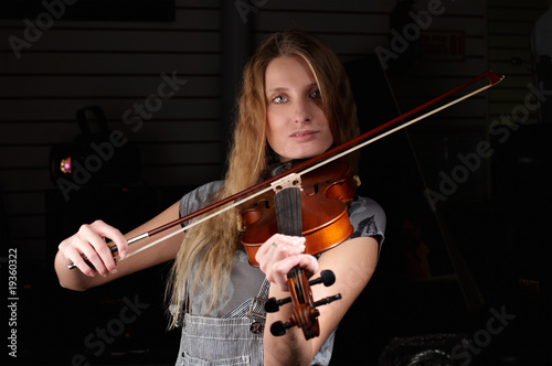 young female play on violin in music study