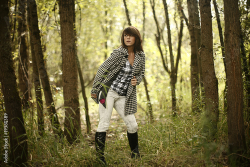A young fashionable woman in a forest. © Peter Kim