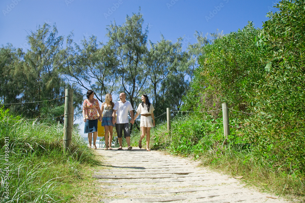 Fototapeta premium family walking from the beach talking and giggeling
