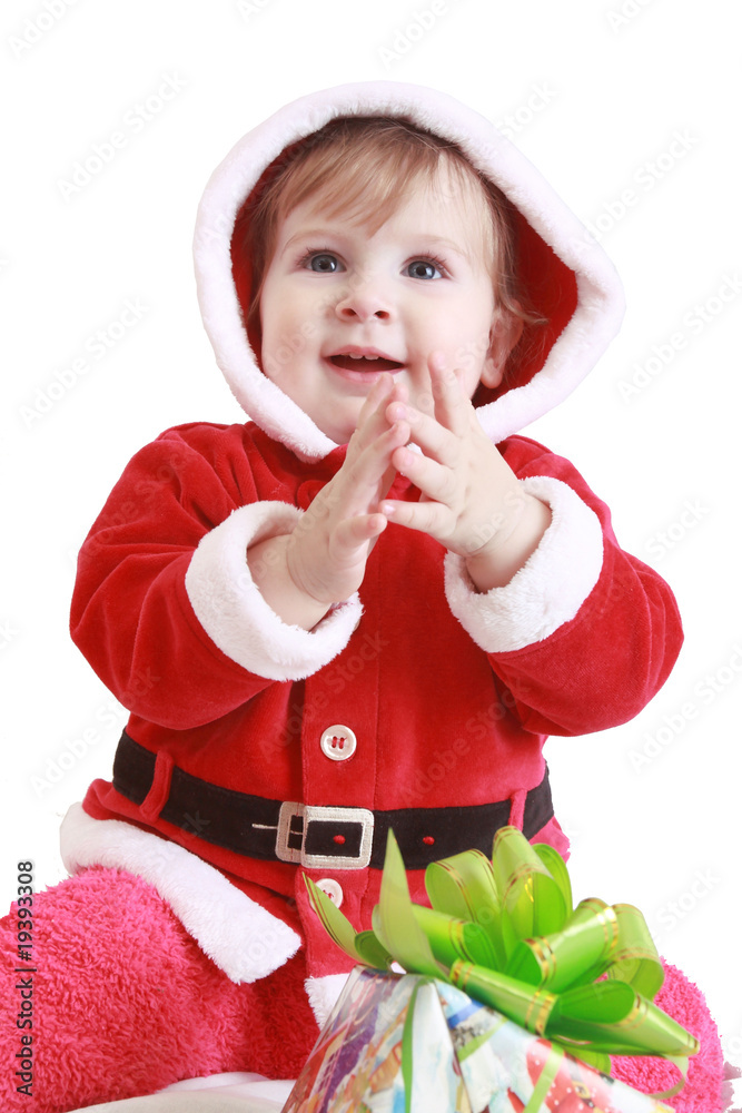 Little happy girl in red santa's clothes clapping in her hands