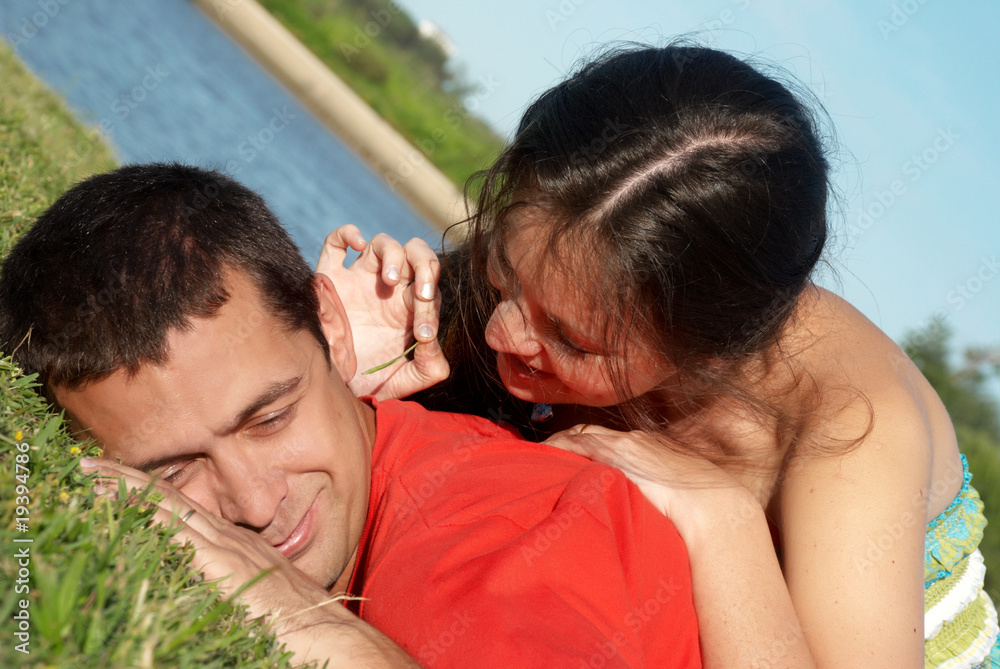 Happy young couple playing at park in grass Happy young couple playing at park in grass