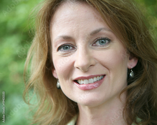 Head shot of a middle aged woman in an outdoor setting