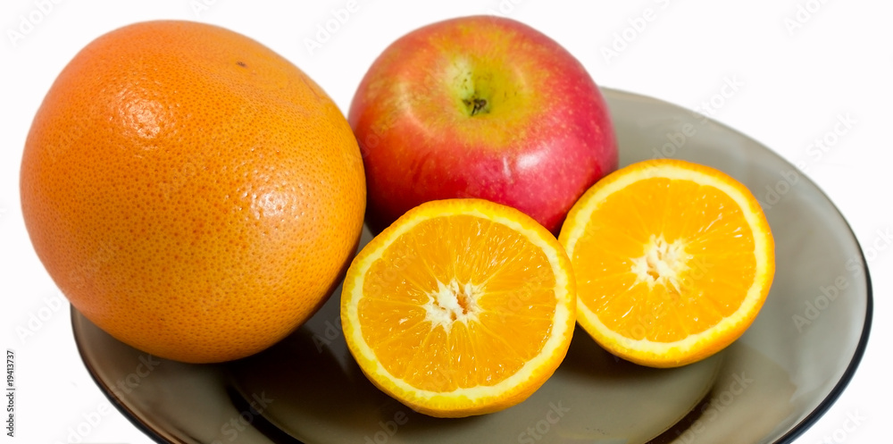 Grapefruit, apple and half of orange on a plate Grapefruit, apple and half of orange on a plate