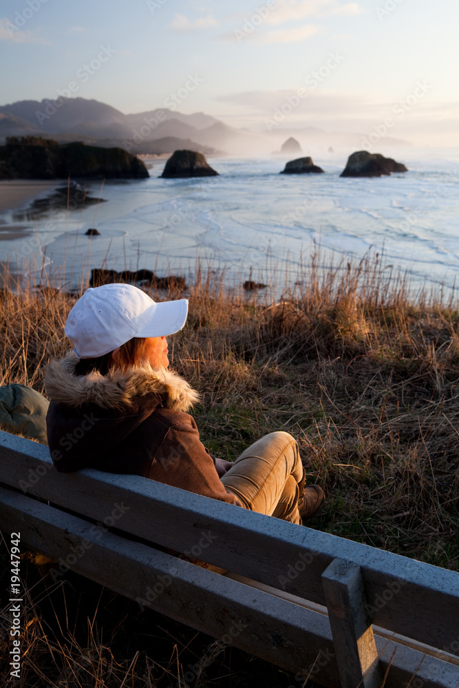 woman on bench overlooking Oregon coast