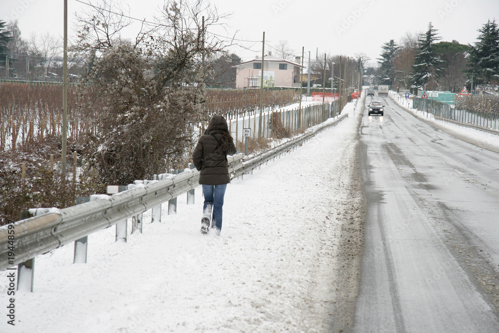 a piedi sulla neve in strada