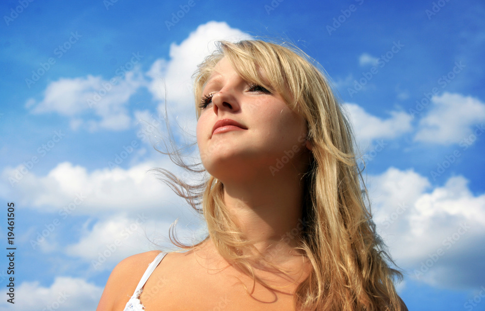 Beautiful blonde girl looking up at clear blue sky Beautiful blonde girl looking up at clear blue sky