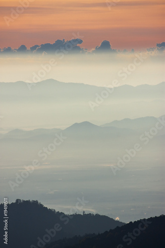 Foggy morning sunrise with high mountain background