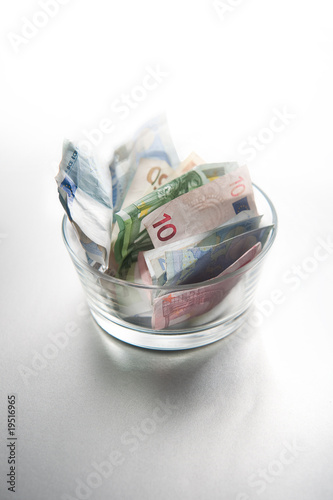 Lots of euro bills folded in a glass bowl