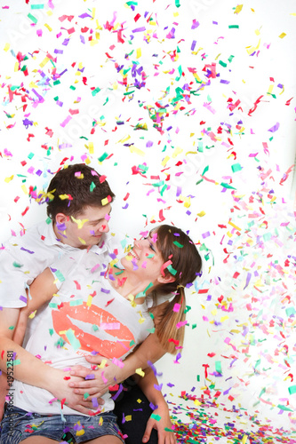 happy loving couple in confetti over white