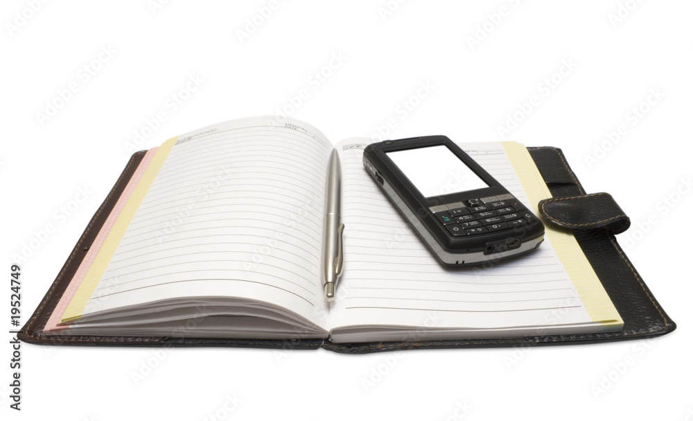 The handle and mobile phone lying on notebook The handle and mobile phone lying on notebook
