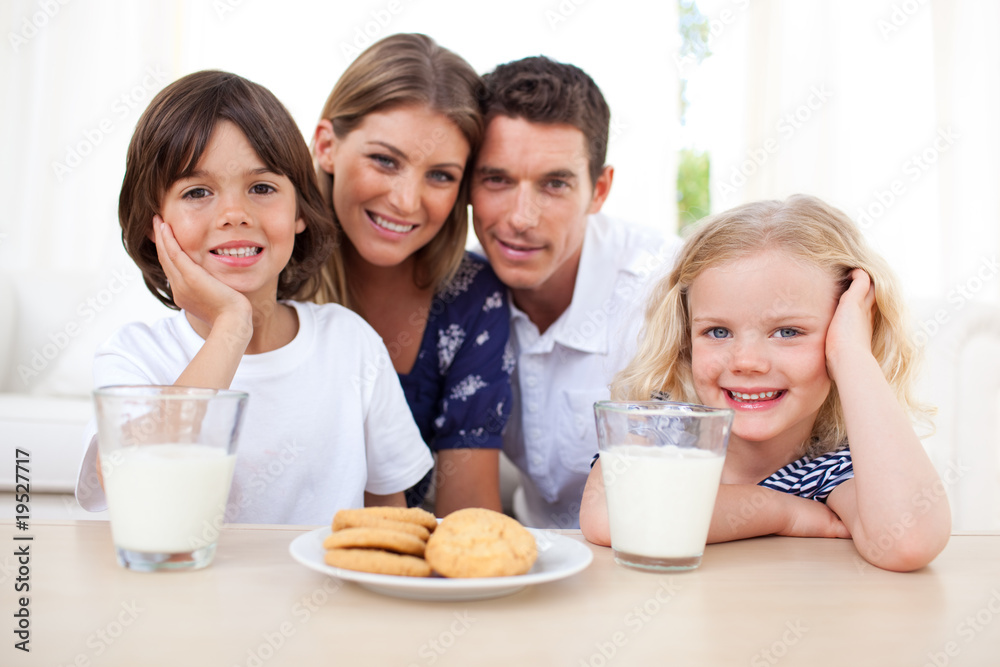 Children eating biscuits and dinking milk with their parents Children eating biscuits and dinking milk with their parents