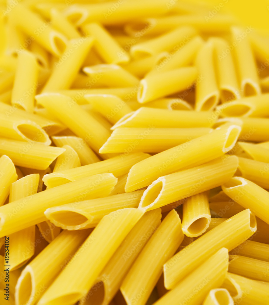 Background from dry raw yellow big spaghetti Background from dry raw yellow big spaghetti