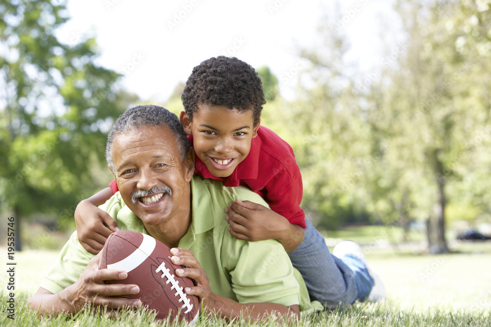 Grandfather With Grandson In Park With American Football Grandfather With Grandson In Park With American Football