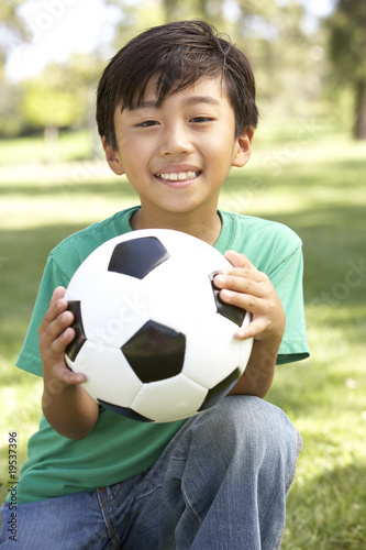 Portrait Of Young Boy In Park With Football © Monkey Business