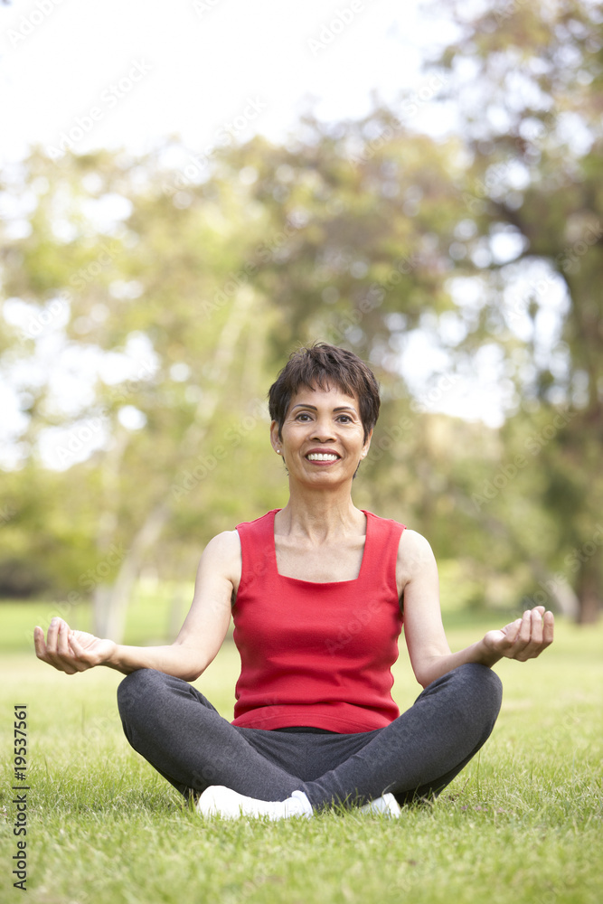 Senior Woman Doing Yoga In Park