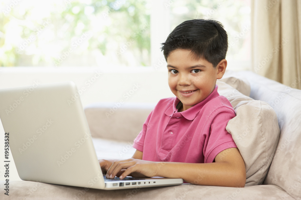 Young Boy Using Laptop At Home Young Boy Using Laptop At Home
