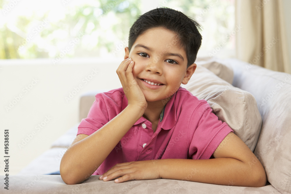 Young Boy Relaxing On Sofa At Home Young Boy Relaxing On Sofa At Home