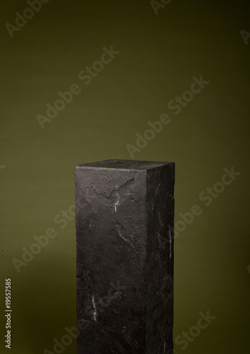 schwarzer Granitsockel vor grünem Hintergrund