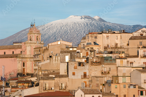 фотографія view of village and belltower on background Etna