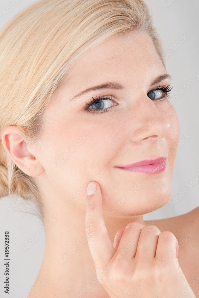Young woman touching her pure healthy skin applying creme Young woman touching her pure healthy skin applying creme
