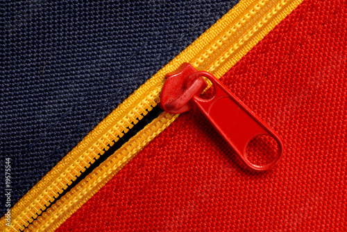 close up of red and blue canvas with yellow zipper