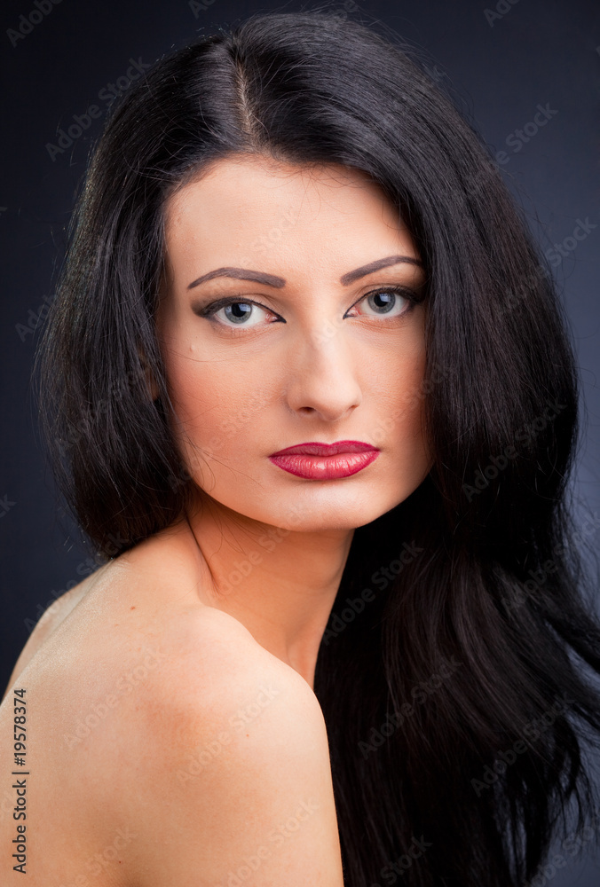 Beautiful young woman face over dark background Beautiful young woman face over dark background