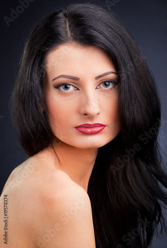 Beautiful young woman face  over dark background